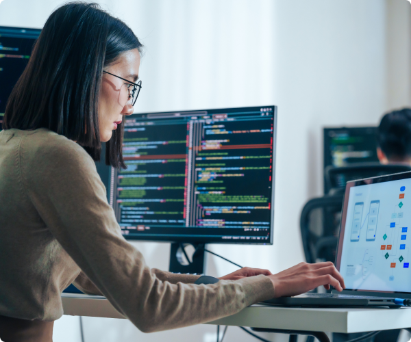 Image of a woman working on a laptop working on a flowchart with a desktop in the background