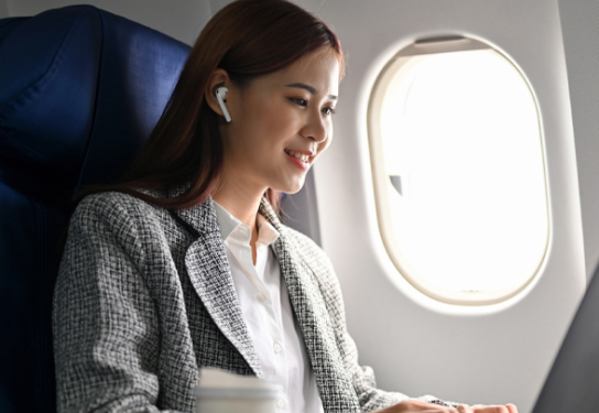 Image of a woman working on her laptop on an airplane