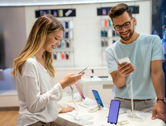 Man and a woman looking at mobile phones in a store