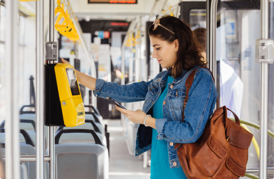 Image of a woman on her mobile phone getting onto a bus