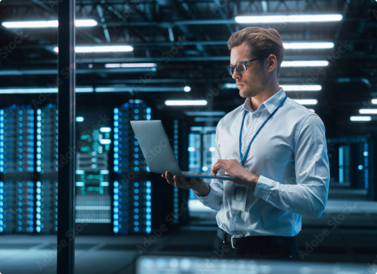 Image of a man working on his laptop in a server room