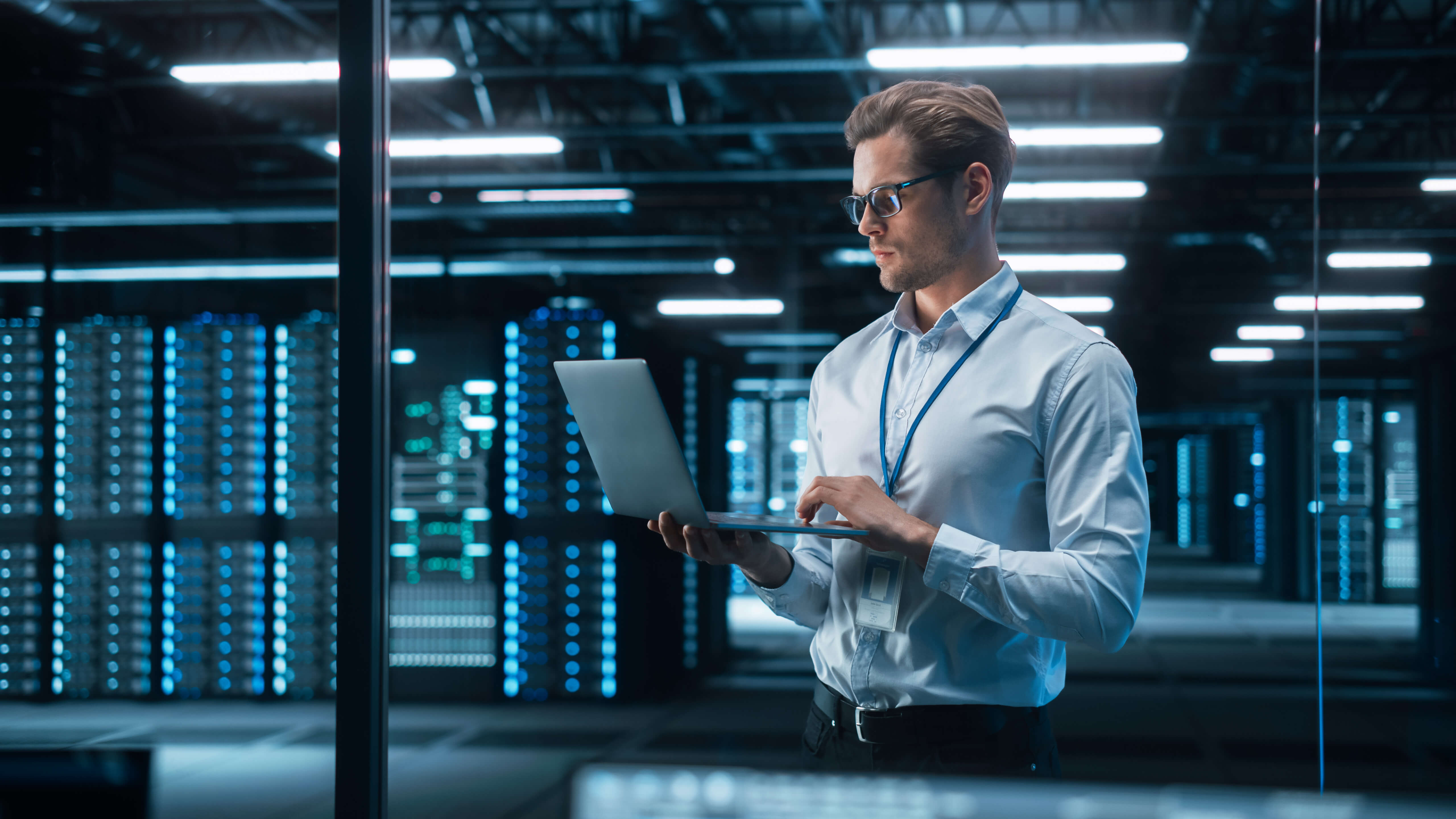 Image of a man working on his laptop in a server room