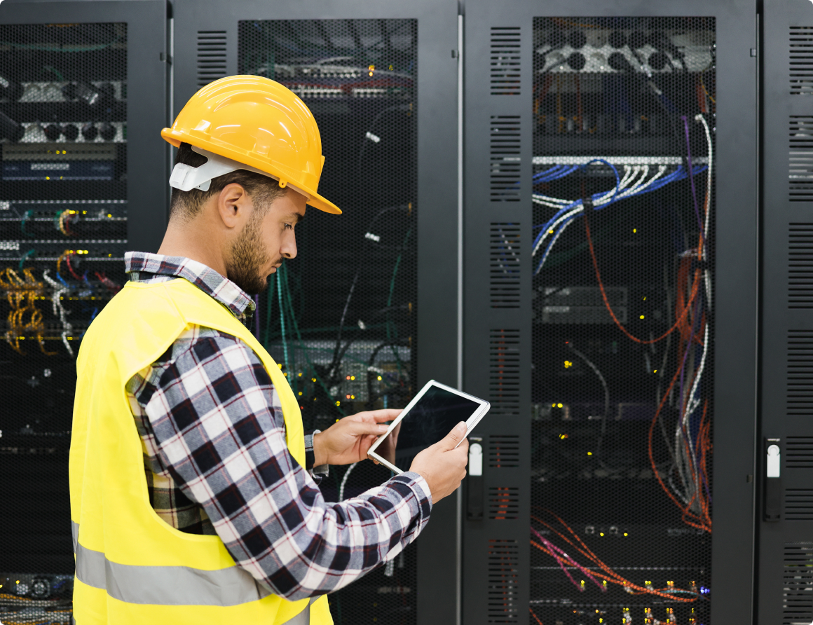 Technician working with tablet inside a data centre room