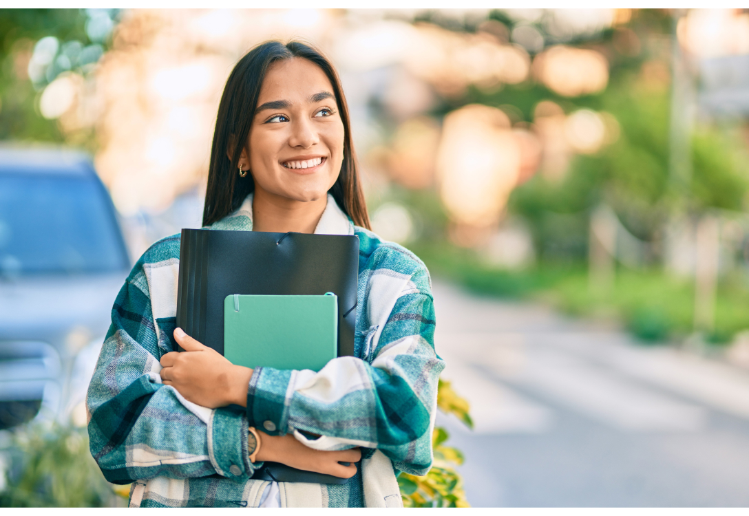 Photo of a student carrying a notebook and a folder