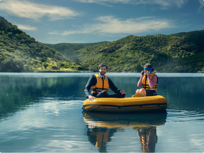 two people sitting in an inflatable dingy on a lake