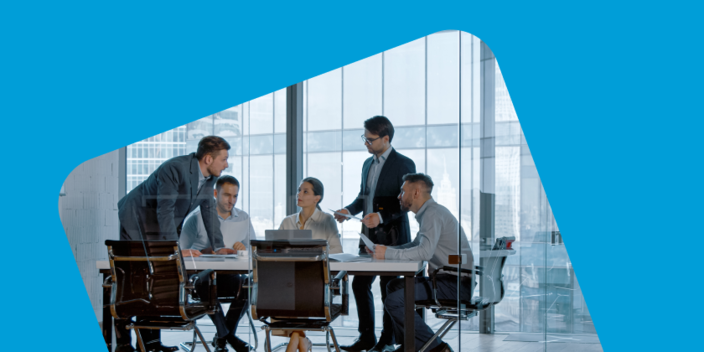 Image of people surrounding a table in a glass walled meeting room having a discussion